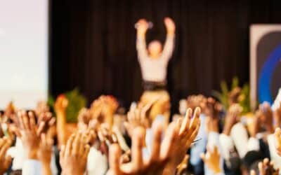 people raising hands with bokeh lights